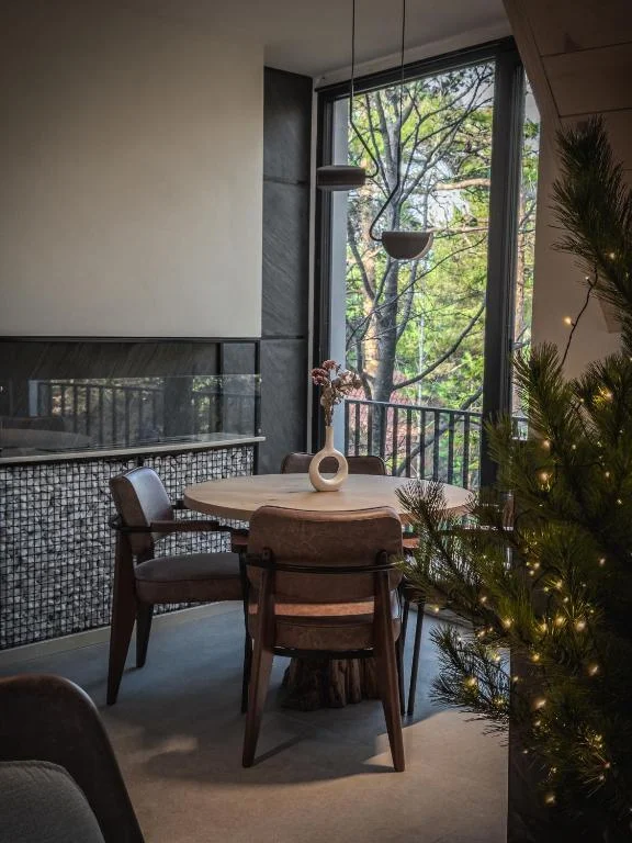 Dining area with round table, forest view and fireplace